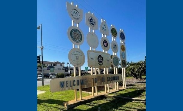 Welcome sign at Main and Imperial with organization logos and says welcome to El Segundo