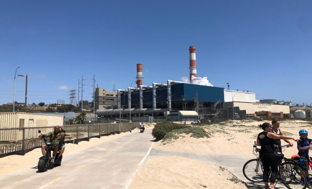 Sand and people riding bikes outside of Scattergood Generating Station