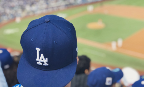 Person wearing Dodgers hat at baseball field