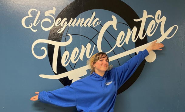 Staff Member posing in front of sign at El Segundo Teen Center