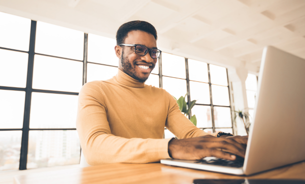 Smiling man using laptop